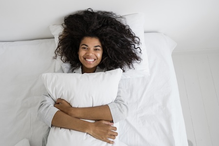 woman lying down and hugging pillow